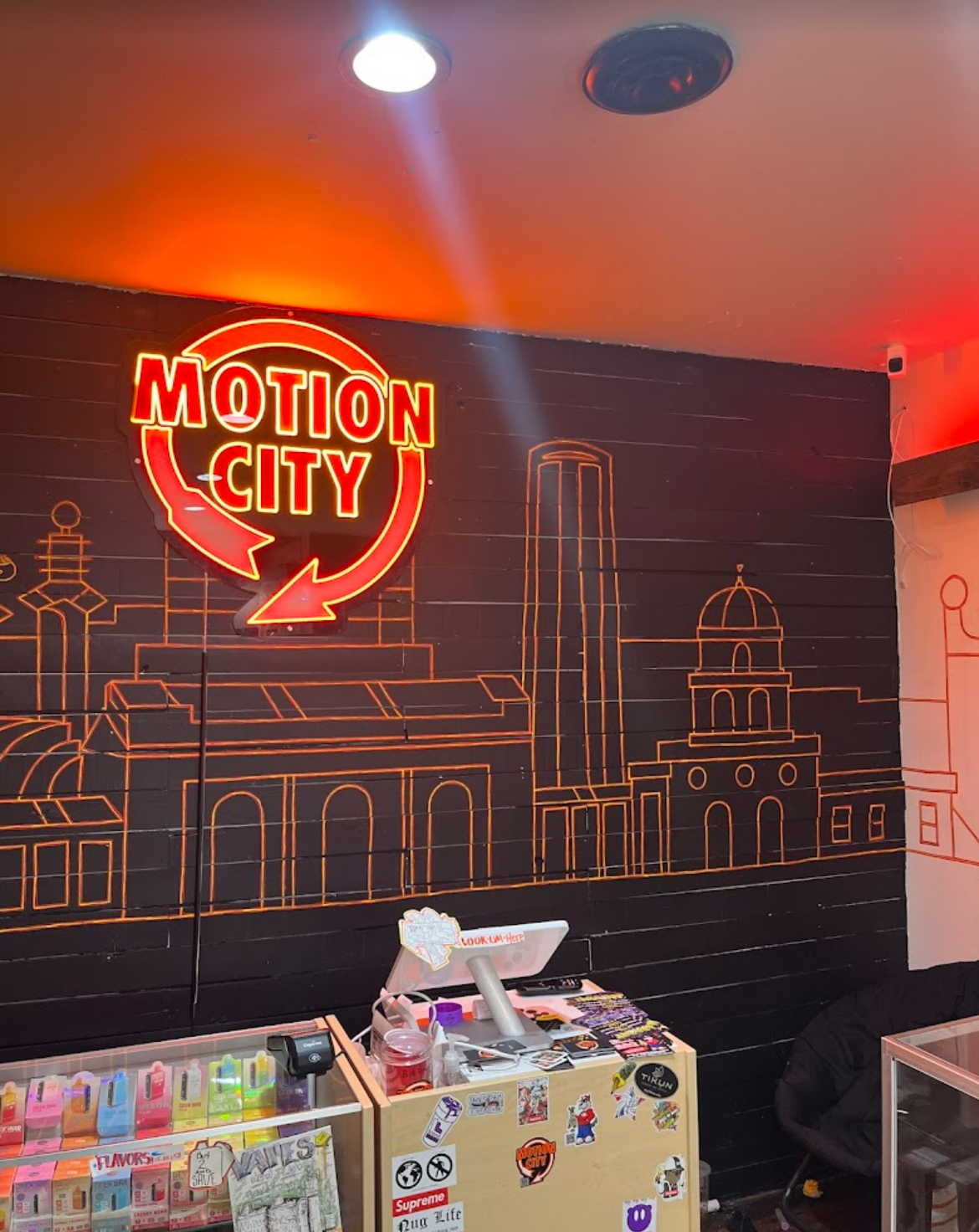 Motion City — red muscle car under KC dispensary neon
